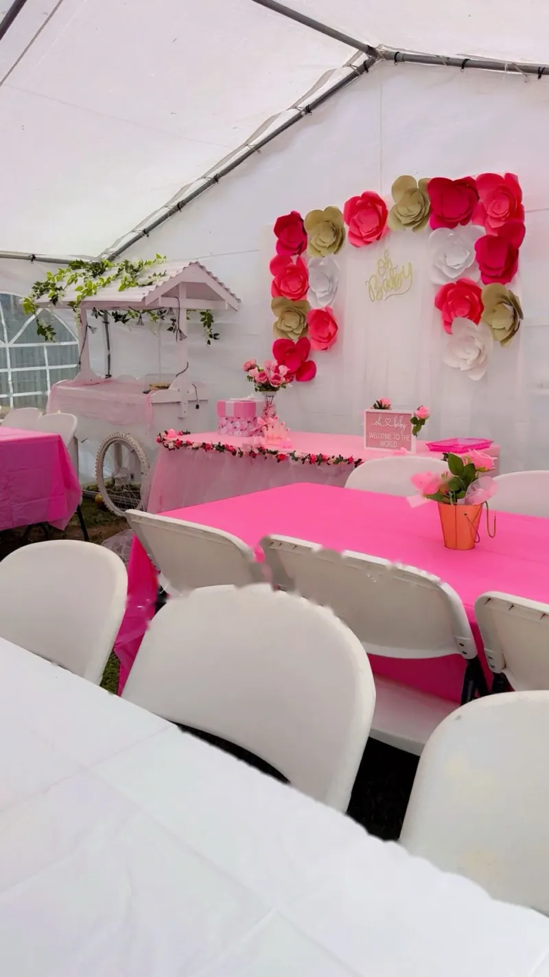 Carpa con un fondo de flores de papel rojas y doradas y mesa rosa