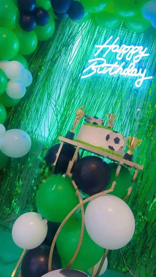Pastel de fútbol entre globos verdes y blancos
